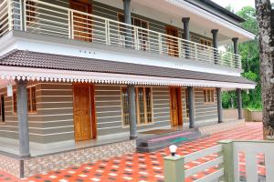 a house with a balcony on top of it at SHANKARAM Homestay in Kodanad