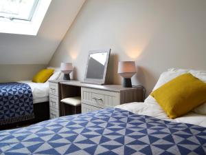 a room with two beds and a desk with a laptop at Lloch Lo in Cilybebyll