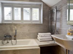 a bathroom with a tub and a sink at Lloch Lo in Cilybebyll