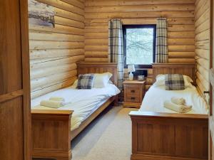 a bedroom with two beds in a log cabin at Tyne Log Cabin - Uk3480 in West Thirston +2 photos