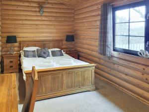 a bedroom with a bed in a wooden room at Tyne Log Cabin - Uk3480 in West Thirston