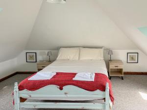 a bedroom with a white bed with a red blanket at Cherry Pip in Uckfield