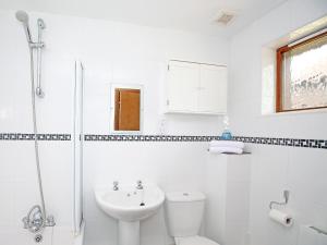 a white bathroom with a toilet and a sink at Cherry Pip in Uckfield
