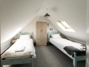 two twin beds in a attic room with two windows at Cherry Pip in Uckfield