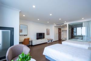 a bedroom with a large white bed and a television at Prime Hotel in Thái Nguyên