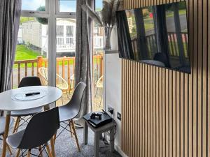 a room with a table and chairs on a balcony at Aspen Lodge - Uk51190 in Morpeth