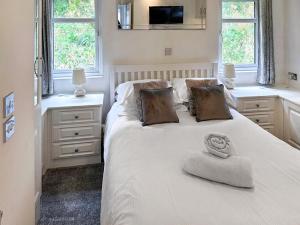 a white bedroom with a bed with a hat on it at Aspen Lodge - Uk51190 in Morpeth