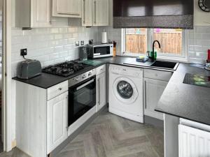 a kitchen with white cabinets and a stove top oven at Aspen Lodge - Uk51190 in Morpeth
