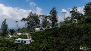 a house on top of a hill with trees at Fortune Glamping in Diyeng