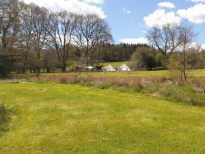 a field of green grass with buildings in the background at Chestnut Cottage in Uckfield