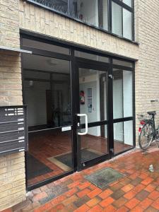 a glass door of a building with a bike parked outside at Ferienappartement Dümmerling in Lembruch in Lembruch +2 photos