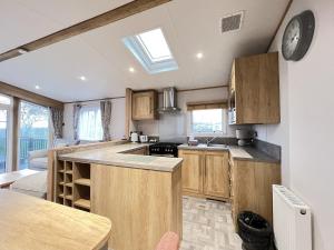 a kitchen with wooden cabinets and a clock on the wall at Glenmoore 23 in St. Andrews