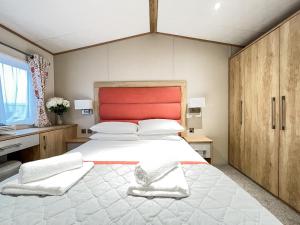 a bedroom with a large white bed with a red headboard at Glenmoore 23 in St. Andrews +5 photos
