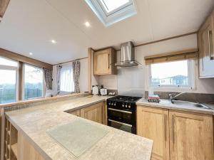 a kitchen with wooden cabinets and a stove top oven at Glenmoore 23 in St. Andrews