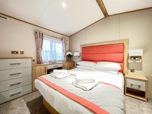 a bedroom with a large bed with a red headboard at Glenmoore 23 in St. Andrews