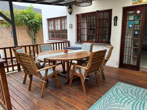 a wooden table and chairs on a wooden deck at Twilight Cottage in Plettenberg Bay