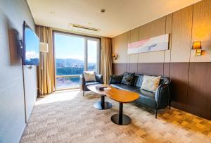 a living room with a couch and a table at Ramada by Wyndham Jeju City Hall in Jeju