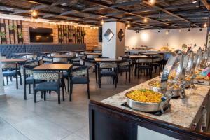 a restaurant with tables and chairs and a counter with food at Wyndham Garden Quito in Quito +123 photos