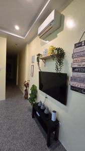 a living room with a flat screen tv on a wall at ShaChi Beach House in Lian