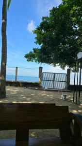 a bench in front of the beach with a dog at ShaChi Beach House in Lian
