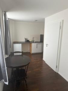 a room with a table and a kitchen with a table and chairs at Studio James in Hombrechtikon