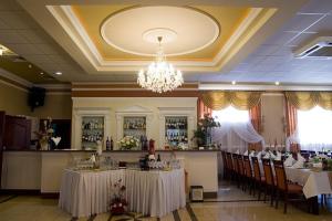 a restaurant with tables and chairs and a chandelier at Amadeus in Łomża