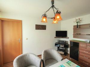 a living room with two chairs and a television at Attractive Bungalow in Ilsenburg with Private Terrace in Ilsenburg