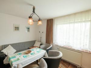 a living room with a couch and a table and chairs at Attractive Bungalow in Ilsenburg with Private Terrace in Ilsenburg