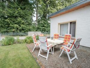 een tafel en stoelen in een tuin bij Attractive Bungalow in Ilsenburg with Terrace in Ilsenburg