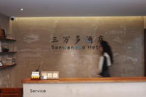 a woman walking past a counter in a store at Huashan Sanwanduo hotel 华山三万多酒店 in Huayin +18 photos