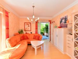 ein Wohnzimmer mit einem orangenen Sofa und einem Tisch in der Unterkunft Apartment near the river in Deggendorf Bavaria in Deggendorf