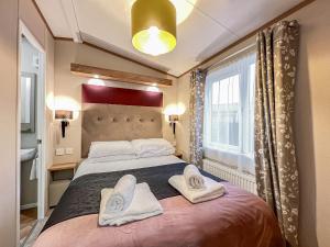 a bedroom with a large bed with towels on it at Abington 14 in St. Andrews