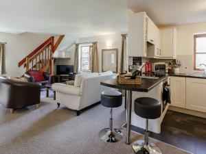 a kitchen and living room with a table and chairs at Honeysuckle - Uk35244 in Llanfyrnach