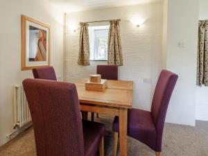 a dining room table with purple chairs and a window at Honeysuckle - Uk35244 in Llanfyrnach +18 photos
