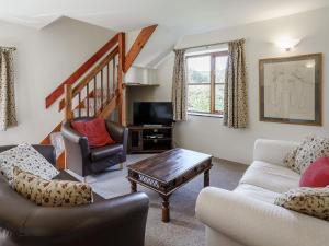 a living room with two couches and a tv at Honeysuckle - Uk35244 in Llanfyrnach