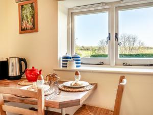 a kitchen with a table and a window at Giddy Cottage - Ukc6127 in Eastdean +12 photos