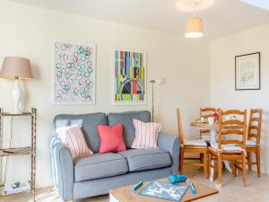 a living room with a blue couch with pink pillows at Hop Cottage - Ukc6134 in Eastdean