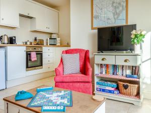 a living room with a red chair and a table at Hop Cottage - Ukc6134 in Eastdean