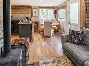 a kitchen and living room with a couch and a table at Rowan Tree Lodge - Ukc6977 in Ludlow