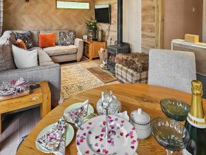 a living room with a table with plates on it at Rowan Tree Lodge - Ukc6977 in Ludlow