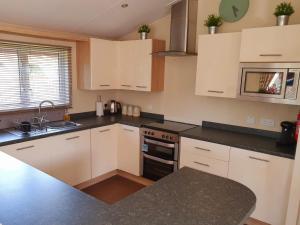 a kitchen with white cabinets and a black counter top at Serenity Lodge-Uk3456 in Felton