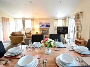 a living room with a table with plates and flowers at Serenity Lodge-Uk3456 in Felton