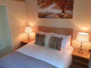 a bedroom with a white bed with two lamps at Serenity Lodge-Uk3456 in Felton