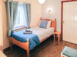 a bedroom with a bed with a blue blanket and a window at Milking Parlour - Uk4017 in Hartington