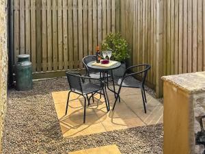 a small table with two chairs and a bottle of wine at Milking Parlour - Uk4017 in Hartington