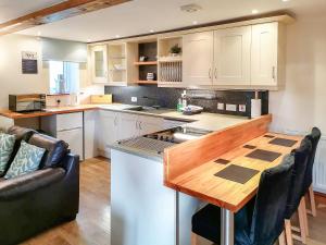 a kitchen with a wooden counter top and a wooden table at Milking Parlour - Uk4017 in Hartington