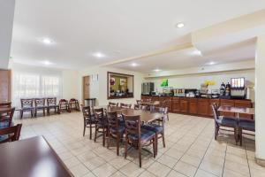 a restaurant with a table and chairs and a kitchen at Quality Inn Lincoln Cornhusker in Lincoln