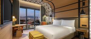 a bedroom with a bed and a view of a city at Canopy By Hilton Izmir Bomonti in İzmir