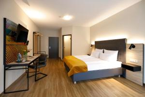 a hotel room with a bed and a desk at Vinotel Dirmstein in Dirmstein