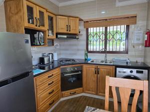a kitchen with wooden cabinets and a stove top oven at Drake Seaside Studio Apartments in Bel Ombre